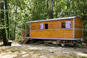 eine Holzhütte im Wald mit einer Leiter in der Unterkunft Aventure Evasion in Chatuzange-le-Goubet