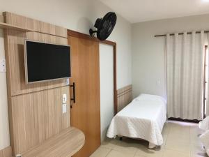 a room with a flat screen tv on a wall at Pousada Giramundo in Teixeiras