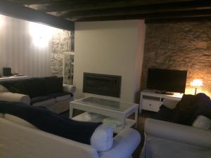 a living room with two couches and a tv at Casa Rural el Rincon de Maria in Villoslada de Cameros