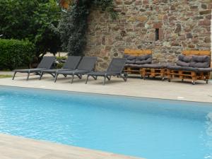 a group of lounge chairs next to a swimming pool at Gîte autonome, La grange a foin, piscine ! in Bergholtz