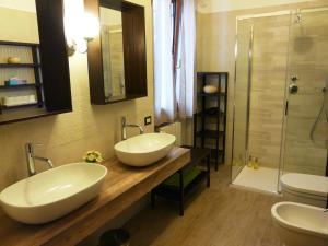 a bathroom with two sinks and a shower at In Giardino B&B in Cassina deʼ Pecchi