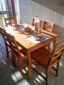 einen Holztisch mit Stühlen und eine Flasche Wasser darauf in der Unterkunft Casa Carmo in Gafanha da Vagueira