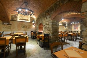 a restaurant with wooden tables and chairs and a stone wall at Appartamenti Medioevo in Varese