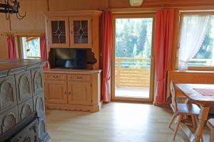 a kitchen with a television and a dining room with a table at Alkira in Sankt Anton am Arlberg