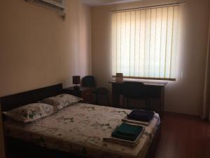 a bedroom with a bed with a table and a window at Pirotska Apartment GN / FREE GARAGE in Sofia