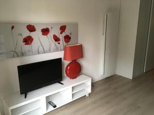 sala de estar con TV y lámpara roja en Studio Plage Royan, en Royan