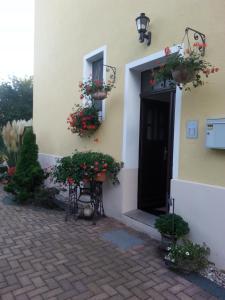 a building with flowering plants and a door with flowers at Ferienzimmer Familie Schmidt in Großdeuben