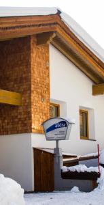 a sign in front of a building in the snow at Alkira in Sankt Anton am Arlberg