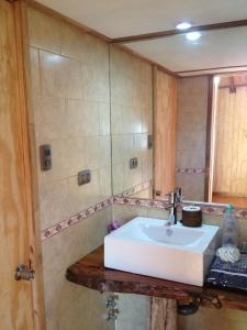 a bathroom with a white sink and a mirror at Cabañas en Malalcahuello con agradable Barbacoa y 2 Estacionamientos Techados in Malalcahuello +29 photos