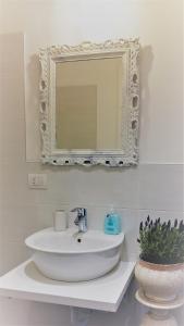 baño con lavabo y espejo en la pared en La Casa dei Sogni, en Brugherio