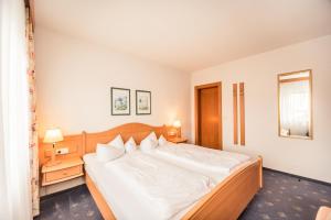 Un dormitorio con una cama grande con sábanas blancas. en Hotel Nordkap, en Ostseebad Karlshagen 31 fotos más