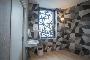 een badkamer met een wastafel en een raam bij Hôtel Mets et Plaisirs in Mazamet