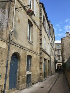 an old building with a blue door on a street at La Maison de Valentine in Bordeaux