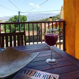 a glass of wine sitting on a wooden table at Casa Sierra de Gredos in Navasequilla