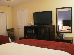 a bedroom with a bed and a flat screen tv at Ocean Village Hotel in Surfside Beach