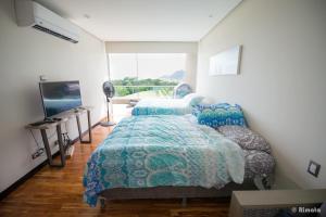 a bedroom with two beds and a flat screen tv at Luxury Beach Apartment Herradura Fishermen And Family in Herradura