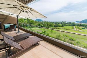 a balcony with two chairs and an umbrella and a table at Luxury Beach Apartment Herradura Fishermen And Family in Herradura