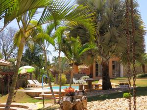 a resort with palm trees and a swimming pool at Chalé da Serra in São João del Rei