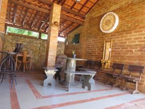 a room with tables and chairs and a brick wall at Chalé da Serra in São João del Rei