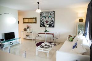 a living room with a white couch and a tiger picture on the wall at Duplex 2bedroom for you in Palm-Mar