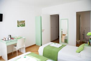 a hotel room with two beds and a desk and a mirror at B&B Botton D'Oro Basiglio in Basiglio