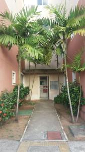 un edificio con dos palmeras delante en Apartamento em Natal/RN, en Natal