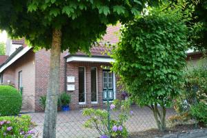a brick house with a fence in front of it at Ferienwohnung Ostfriesenglück in Leer