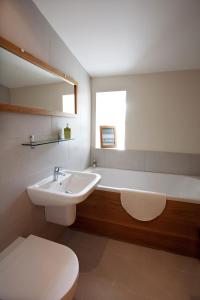 een badkamer met een wastafel, een bad en een toilet bij Inglenook Cottage in Wandylaw