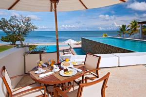 un tavolo con cibo su un patio con vista sull'oceano di Las Verandas Hotel & Villas a First Bight