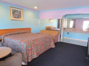 een hotelkamer met een bed en een spiegel bij Starlight Inn Van Nuys in Van Nuys