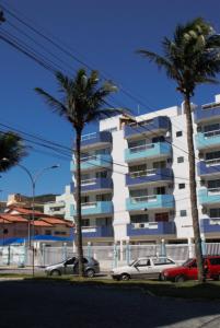 dos palmeras delante de un edificio en Rental Home Caminho do Mar Prainha, en Arraial do Cabo