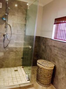 a bathroom with a shower with a glass door at Lazy Days Apartments - Lambert's Bay in Lambertʼs Bay