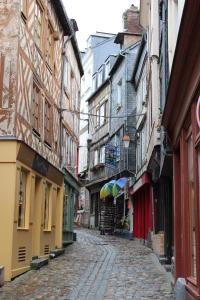 een geplaveide straat in een oude stad met gebouwen bij Les Maisons de Maje - Le Lingot in Honfleur