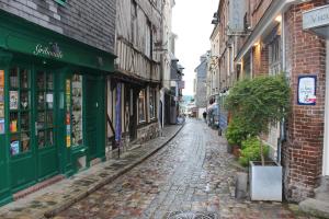 een geplaveide straat in een steeg met gebouwen bij Les Maisons de Maje - Le Lingot in Honfleur
