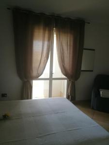 um quarto com uma cama e uma grande janela em A...Mikimari em Quartu SantʼElena