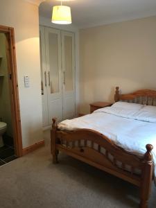 a bedroom with a wooden bed and a bathroom at High Road Cottage in Achill