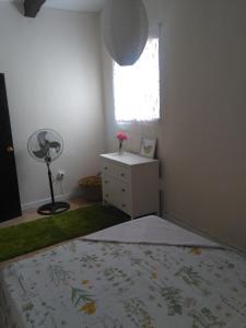 ein Schlafzimmer mit einem Bett, einer Kommode und einem Fenster in der Unterkunft La Casita de Silvia in Alhaurín de la Torre