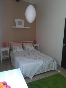 ein Schlafzimmer mit einem Bett, zwei Tischen und einer Lampe in der Unterkunft La Casita de Silvia in Alhaurín de la Torre