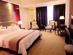 a hotel room with a large bed and chairs at Rongjiang Hotel in Jieyang