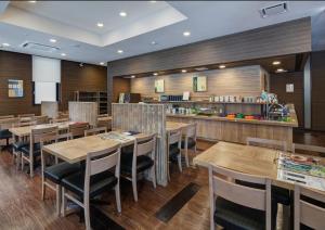 a restaurant with wooden tables and chairs and a counter at Hotel Route-Inn Oshu in Oshu