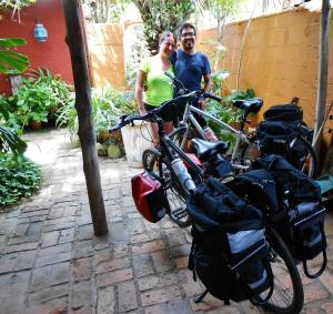 a man and a woman standing next to their bikes at Hostel La Cruz del Sur in La Paloma