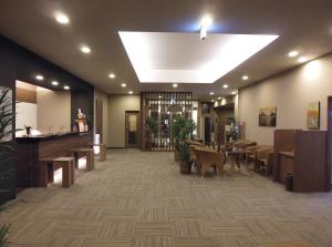 a lobby with a waiting area with tables and a piano at Hotel Route Inn Tagajo-Eki Higashi in Tagajo