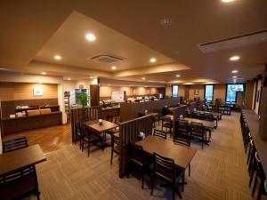 a restaurant with tables and chairs and a bar at Hotel Route Inn Tagajo-Eki Higashi in Tagajo