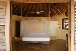 
a bedroom with a bed and a canopy at Posada y Pizzeria La Termita in San Agustinillo
