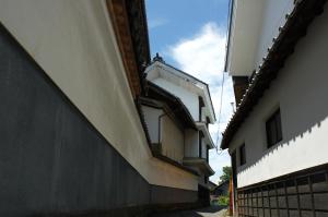 a building with a balcony on the side of it at Guest House Kura in Suzaka