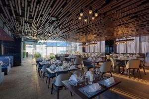 ein Esszimmer mit Tischen und Stühlen in der Unterkunft Belle Maison Parosand Da Nang Hotel -managed by H&K Hospitality in Đà Nẵng