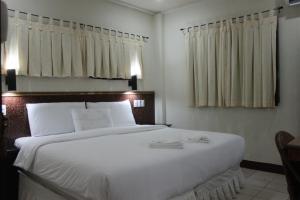 a bedroom with a large white bed with two towels on it at Lost Horizon Beach Dive Resort in Panglao Island