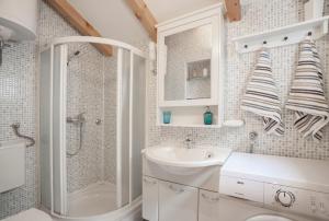 een witte badkamer met een wastafel en een douche bij Guesthouse F in Split