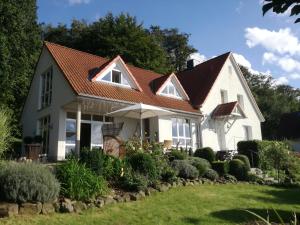 een wit huis met een bruin dak bij Ferienwohnung am Benther Berg in Gehrden