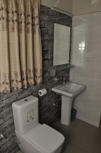 a bathroom with a toilet and a sink at Serenity Sigiri Resort in Sigiriya